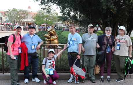 Highlight Vacations travelers posing with Winnie the Pooh golden statue