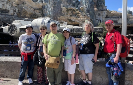 Highlight Vacations travelers posing with the Millennium Falcon from Star Wars.