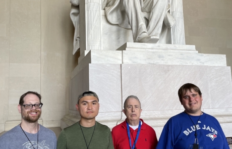 Highlight Vacations travelers standing in front of the Lincoln Memorial statue.