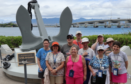 Highlight Vacations travelers standing in front of the Anchor from the USS Arizona