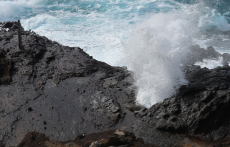 Photo of the Halona blowhole with the waves crashing into the rocks.