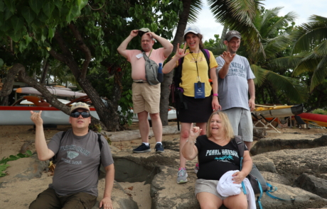 Highlight Vacations travelers looking into the camera and giving the Hawaii sign Shaka