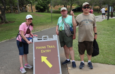 Highlight Vacations travelers posing in front of the Hiking trail entry for Diamond Head State Monument