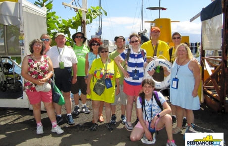 Highlight Vacations travelers and staff posing in front of the semi-submarine reefdancer