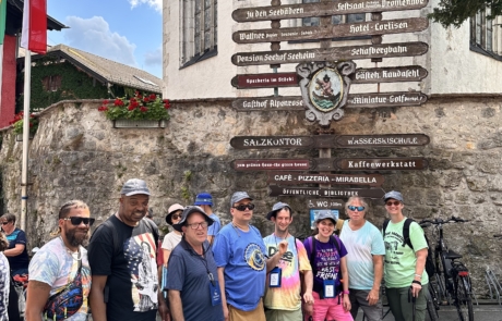 Staff and travelers in front of the town sign.