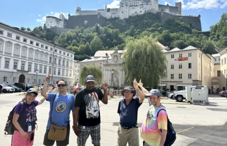 Travelers pointing to Fort Hohensalzburg in the background on hill