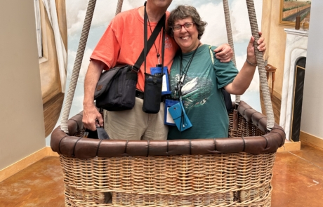 Two travelers are in a hot air balloon basket.