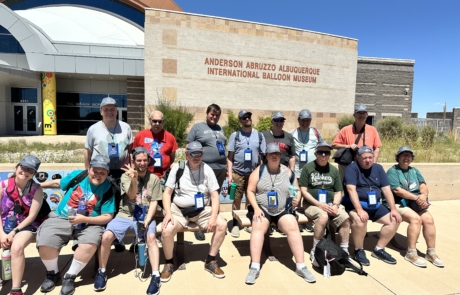 the group sitting in front of the Anderson Abruzzo Albuquerque international balloon museum