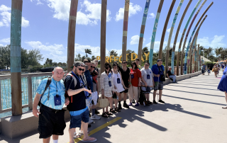 The travelers standing in front of the sign the "Perfect Day"