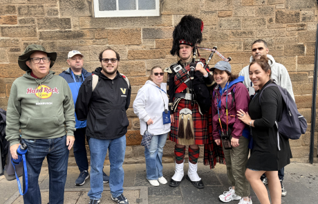 Travelers with a Scottish bag piper in Edinburgh, Scotland.