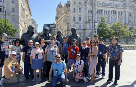 The travelers standing in front of the Beatles statue.